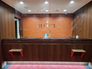 A reception desk with a wooden backdrop and the text "AI HOTEL" above it. - Ai Hotel Hashimoto (Sagamihara)