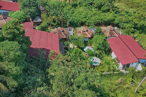 A cluster of houses with red roofs surrounded by dense greenery. - Ayu Hotel Karimunjawa (Karimun Jawa)