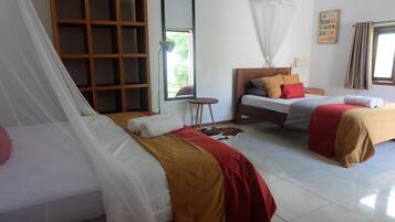 A room with two beds, a bedside table, a mirror, a window with curtains, and a wall with a motivational quote.