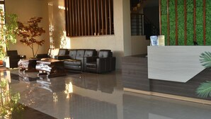 A modern lobby with a reception desk, seating area, and a staircase. - Padadita Beach Hotel (Waingapu)