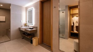 A modern bathroom with a wooden vanity, a mirror, and a glass shower enclosure. - Holiday Inn Sepang Airport (Sepang)