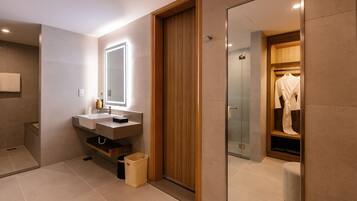 A modern bathroom with a wooden vanity, a mirror, and a glass shower enclosure.