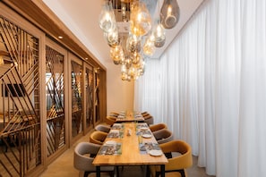 A dining area with a long table, chairs, and a modern chandelier. - Holiday Inn Sepang Airport (Sepang)