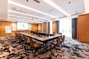 A conference room with a large table, chairs, a whiteboard, and a presentation screen. - Holiday Inn Sepang Airport (Sepang)