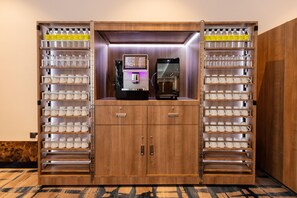 A minibar with multiple shelves of bottles and glasses, a coffee machine, and a small screen. - Holiday Inn Sepang Airport (Sepang)
