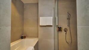 A modern bathroom with a bathtub, a glass-enclosed shower, and a towel rack. - Holiday Inn Sepang Airport (Sepang)