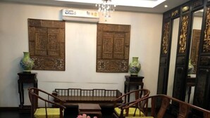 A traditional room with a wooden sofa set, a dining table, and a chandelier. - Hotel IYA (Khlong Luang)