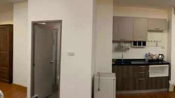 A modern kitchen with wooden cabinets, a refrigerator, and a microwave.