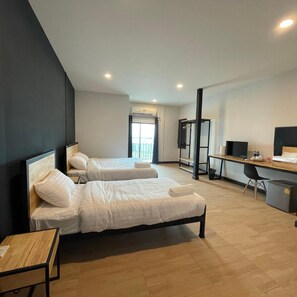 Een moderne hotelkamer met twee bedden, een bureau en een stoel.