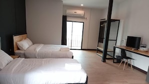 Une chambre d’hôtel avec deux lits, un bureau, une télévision et un appareil de climatisation.