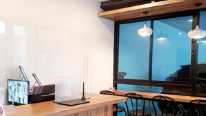 A modern bar area with wooden counter, black chairs, and a large window with a view. - Suhotel Suratthani (Surat Thani)