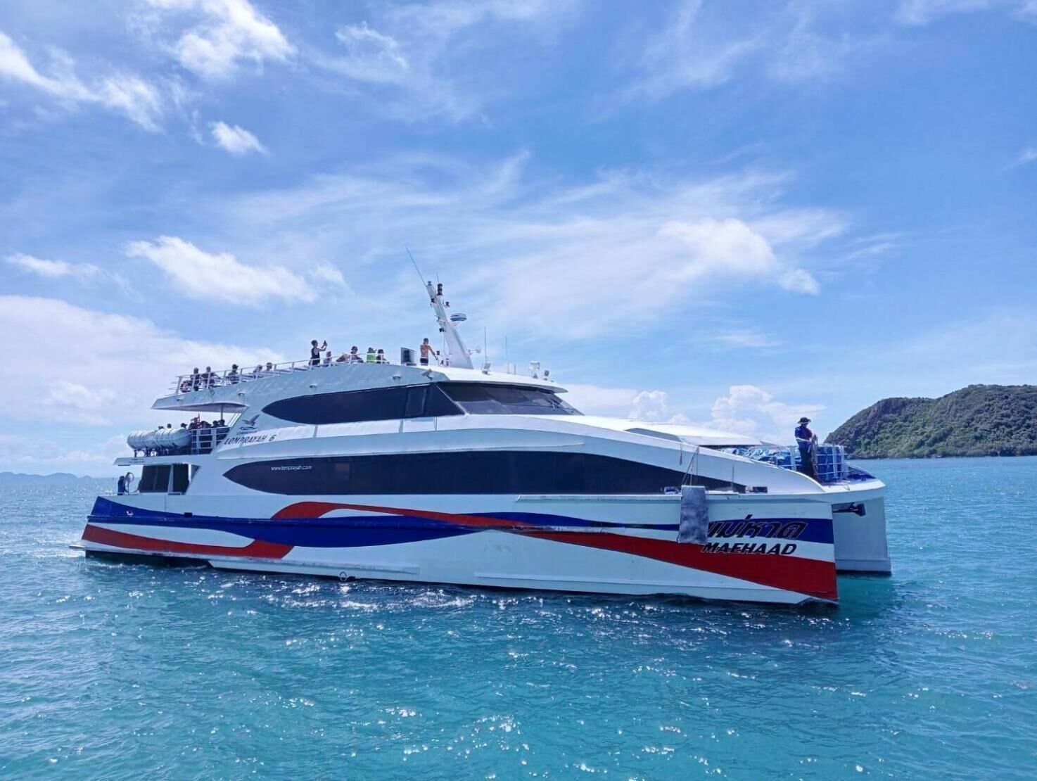 Un yate grande con varias cubiertas y un logotipo destacado en el costado.