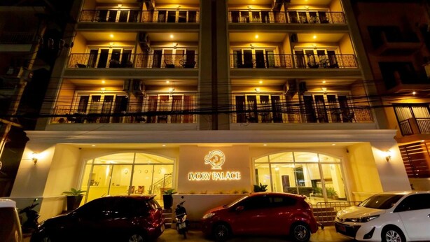 A multi-story hotel with balconies on each floor, a prominent sign reading "Ivory Palace," and cars parked in front. - Ivory Palace Hotel (Pattaya)