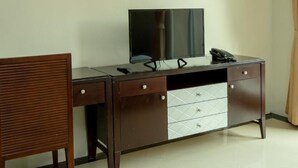A room with a desk, a chair, a television, and an air conditioning unit. - Ivory Palace Hotel (Pattaya)
