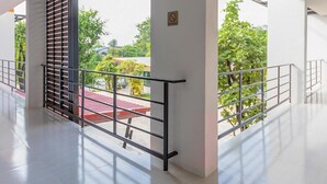 Un interior moderno con un panel de vidrio, barandillas metálicas y vistas a zonas verdes.
