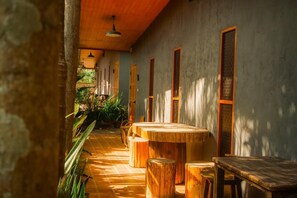 Un corridoio con arredamento in legno e pavimento piastrellato, che porta a una stanza con tavolo e sedie in legno.