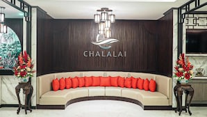 A reception area with a curved sofa, a chandelier, and a wall-mounted sign reading 'CHALALAI.' - Chalalai Hotel Krabi (Nuea Khlong)