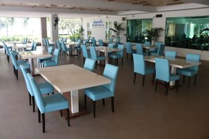 A spacious dining area with multiple tables and chairs, large windows, and indoor plants. - Seapine Beach Golf and Resort Hua Hin (Hua Hin)