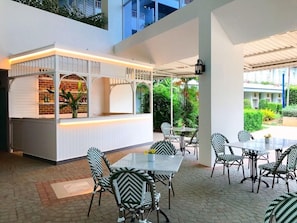 A restaurant with a white counter, black and white patterned chairs, and tables. - Seapine Beach Golf and Resort Hua Hin (Hua Hin)