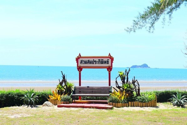 A beach with a bench and a sign in front of the water. - Seapine Beach Golf and Resort Hua Hin (Hua Hin)