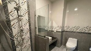 Un baño moderno con ducha, inodoro y lavamanos.