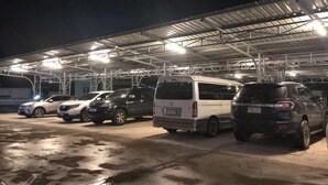 A parking garage with multiple vehicles parked under a metal roof structure. - Grandview Landmark Betong Hotel (Betong)