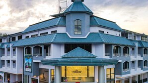 A hotel with a distinctive blue roof and a central entrance with a glass canopy. - Grandview Landmark Betong Hotel (Betong)