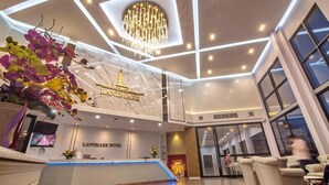 A modern hotel lobby with a marble reception desk, a chandelier, and a large window overlooking the interior. - Grandview Landmark Betong Hotel (Betong)
