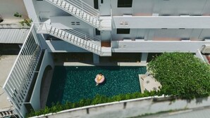 Edifici modern amb diverses plantes, un pati central amb piscina i una escala que connecta els pisos.