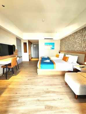 Una camera d'albergo con un letto, una scrivania, un televisore e un quadro appeso al muro.
