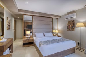 A modern hotel room with a large bed, bedside tables with lamps, a wardrobe, and an air conditioning unit. - Nozol Pyramids Hotel (Giza)