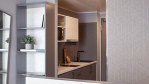 A modern kitchen with built-in appliances, a countertop, and a backsplash. - Candlewood Suites Dusseldorf Airport (Düsseldorf)