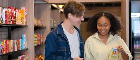 A man and a woman shopping in a store aisle with shelves stocked with various products.