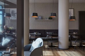 A modern interior with seating, pendant lighting, and a visible window. - Candlewood Suites Dusseldorf Airport (Düsseldorf)