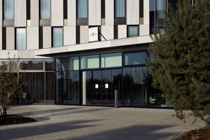 A modern building with large glass windows, a flat roof, and a signboard. - Candlewood Suites Dusseldorf Airport (Düsseldorf)