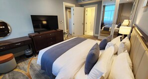 A hotel room with a bed, a TV, a dresser, and a mirror. - Shraao Hotel (Doha)