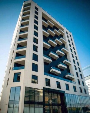 A high-rise building with multiple balconies, large windows, and a modern architectural design. - Shraao Hotel (Doha)