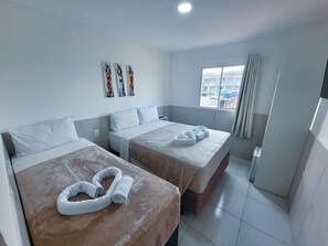 A hotel room with two beds, a window with a view, and artwork on the wall. - Atlantico Sul Hotel Porto de Galinhas (Ipojuca)