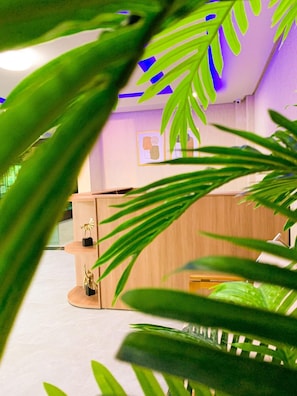 Ein moderner Arbeitsbereich mit einem Holztisch, zwei goldenen Statuen und einer Wand mit abstrakter Kunst.