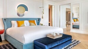 Een moderne slaapkamer met een groot bed, een nachtkastje en een spiegel.