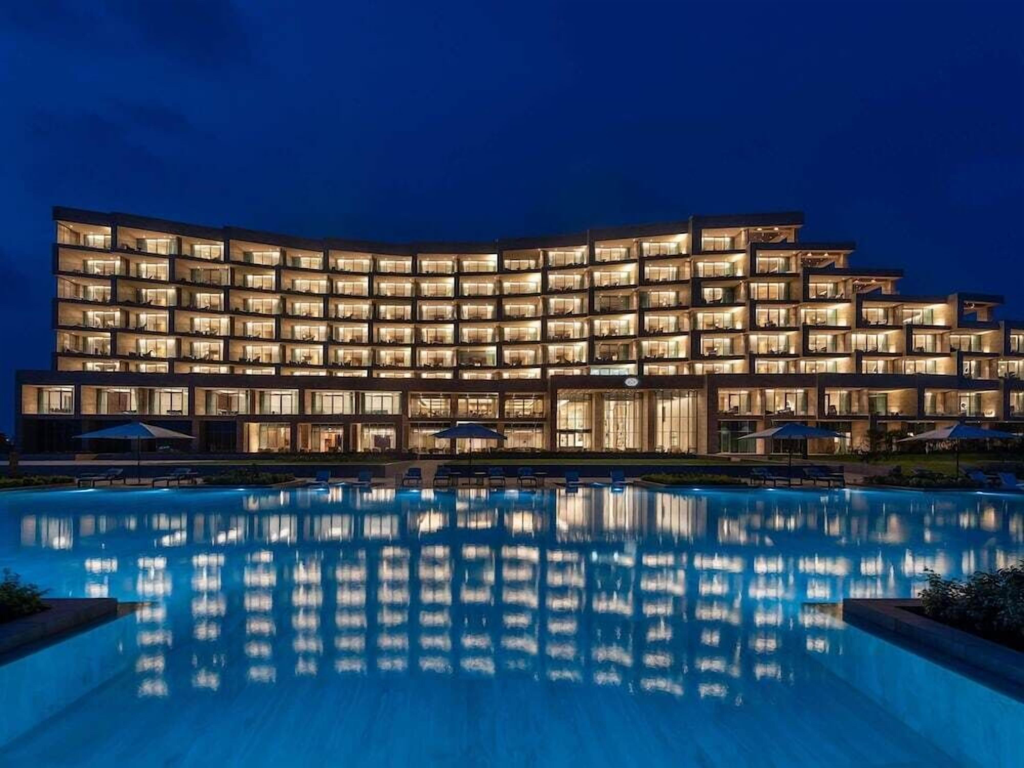 Un hôtel à plusieurs étages avec une piscine à l’avant.