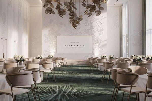 Un espace événementiel élégant, doté d’un tapis vert, de compositions florales blanches et d’une enseigne indiquant « SOFITEL HOTELS & RESORTS ».