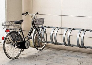 A bicycle parked next to a metal bike rack. - Holiday Inn Express & Suites Deventer (Deventer)