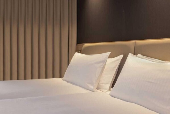 A hotel room with a large bed, a dark headboard, and vertical blinds. - Holiday Inn Express & Suites Deventer (Deventer)