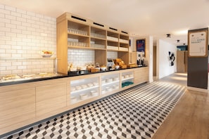 Een moderne ontbijtbar met diverse etenswaren en een koffiehoek.