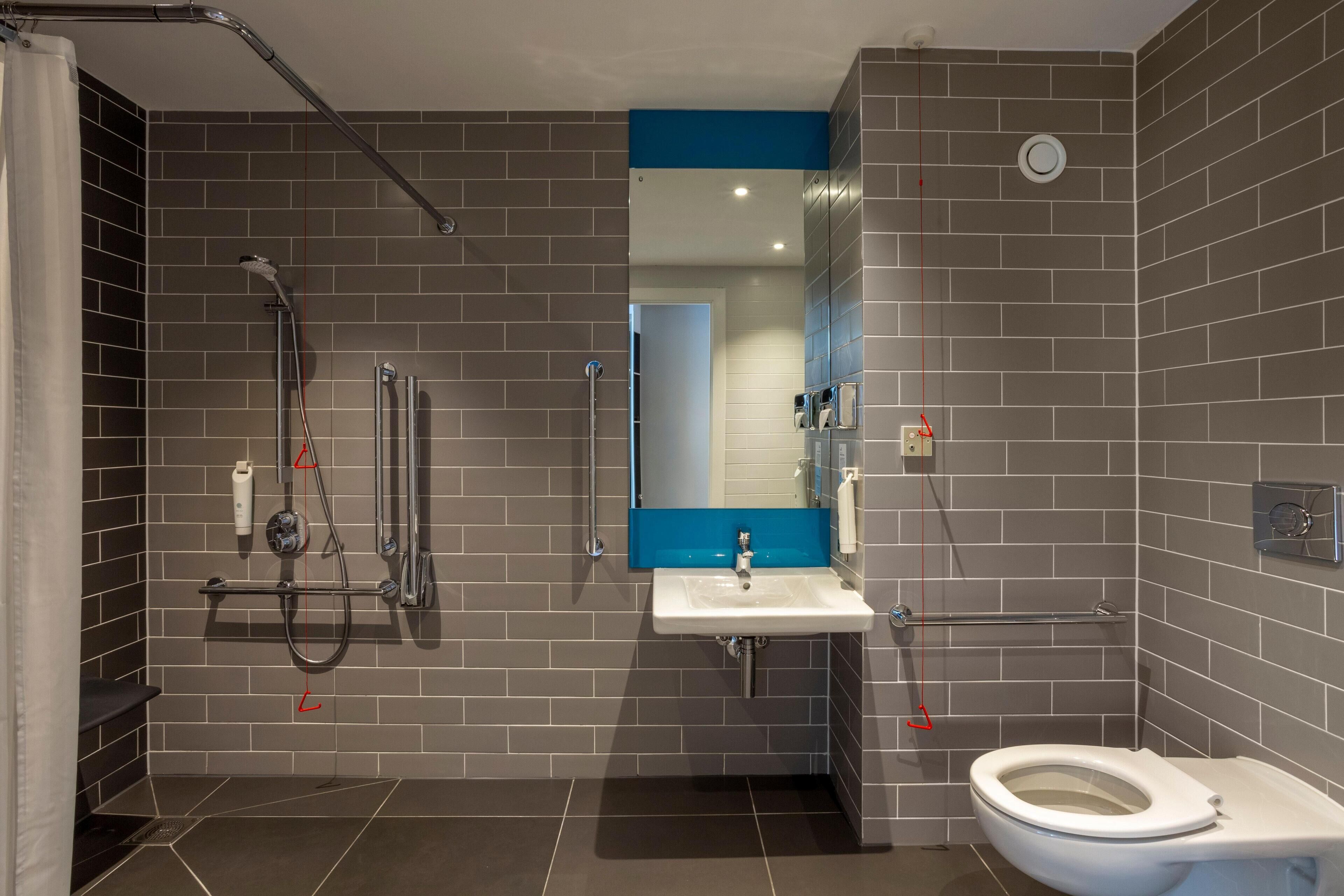 Une salle de bain moderne équipée d’une douche, de toilettes et d’un lavabo.