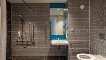 Une salle de bain moderne équipée d’une douche, de toilettes et d’un lavabo.