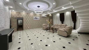 A modern hotel lobby with a marble floor, a sectional sofa, and a desk. - ADA Hotel Tashkent (Tashkent)