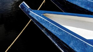 A close-up of a boat's blue and white hull with a rope tied to it. - De Dames Van De Jonge Hotel Restaurant (Giethoorn)