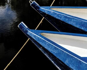 A close-up of a boat's blue and white hull with a rope tied to it. - De Dames Van De Jonge Hotel Restaurant (Giethoorn)